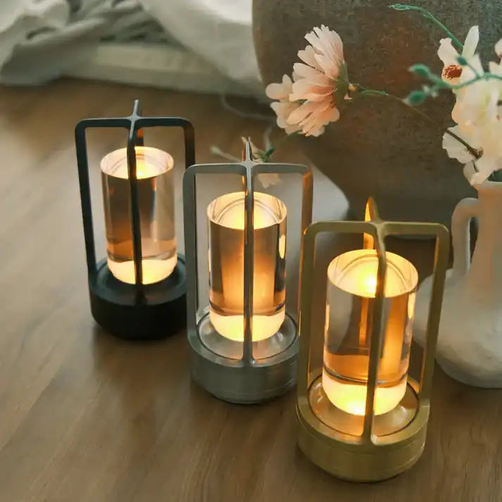 trio-decorative-lanterns-clear-glass-cylinder-illuminated-amber-glow-encased-distinct-black-silver-gold-metal-frames.webp